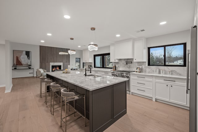 21725 Normandale St, Beverly Hills, MI 48025 - kitchen featuring stainless steel stove, a sink, white cabinets, decorative backsplash, and recessed lighting