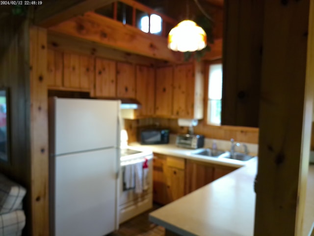2305 Ridge Rd, White Lake, MI 48383 - kitchen featuring freestanding refrigerator, a sink, light countertops, extractor fan, and decorative light fixtures