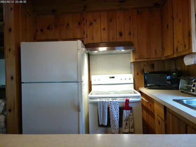 2305 Ridge Rd, White Lake, MI 48383 - kitchen featuring white appliances, under cabinet range hood, brown cabinetry, and light countertops