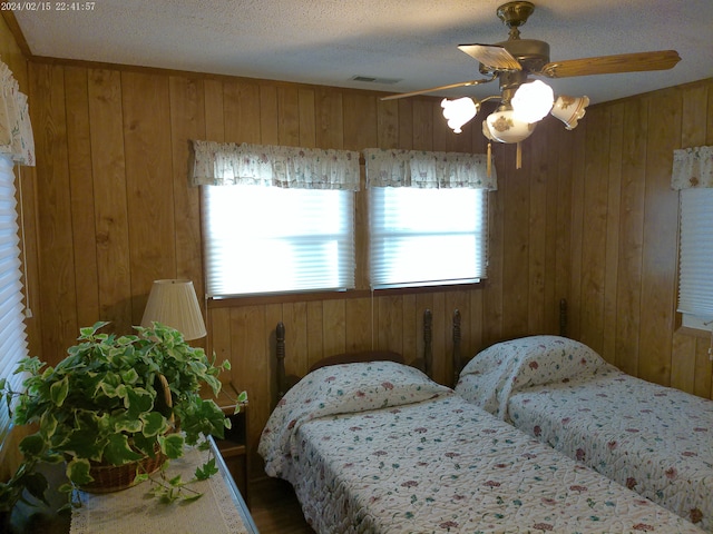 2305 Ridge Rd, White Lake, MI 48383 - bedroom with wood walls, ceiling fan, a textured ceiling, and wood finished floors