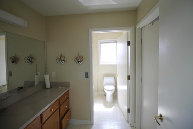 bathroom with vanity, baseboards, and toilet