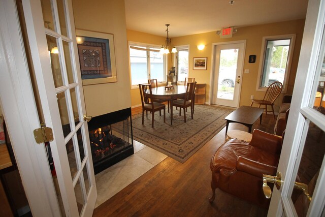 dining area with baseboards, wood finished floors, and a notable chandelier