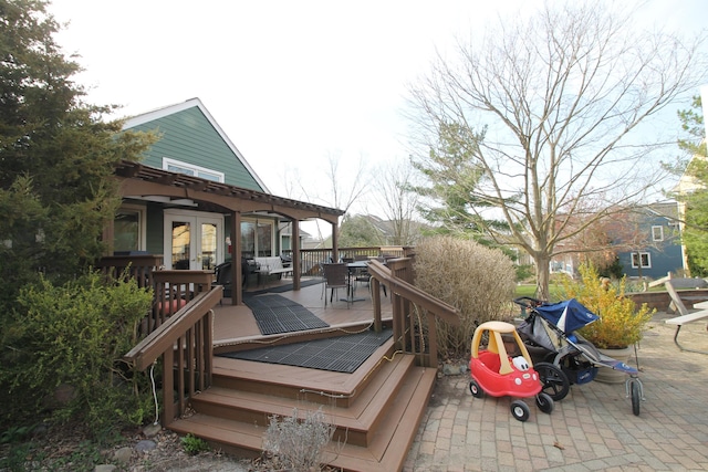 wooden terrace with french doors and outdoor dining space
