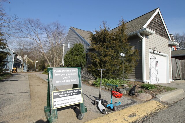 exterior space with a garage and roof with shingles