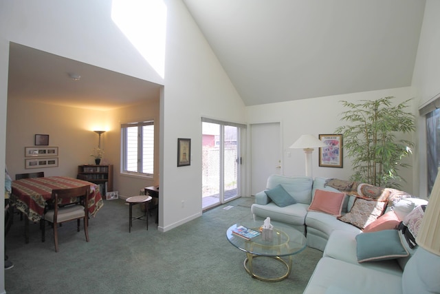 living room with high vaulted ceiling, baseboards, and carpet