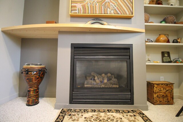interior details with a glass covered fireplace, carpet floors, and baseboards