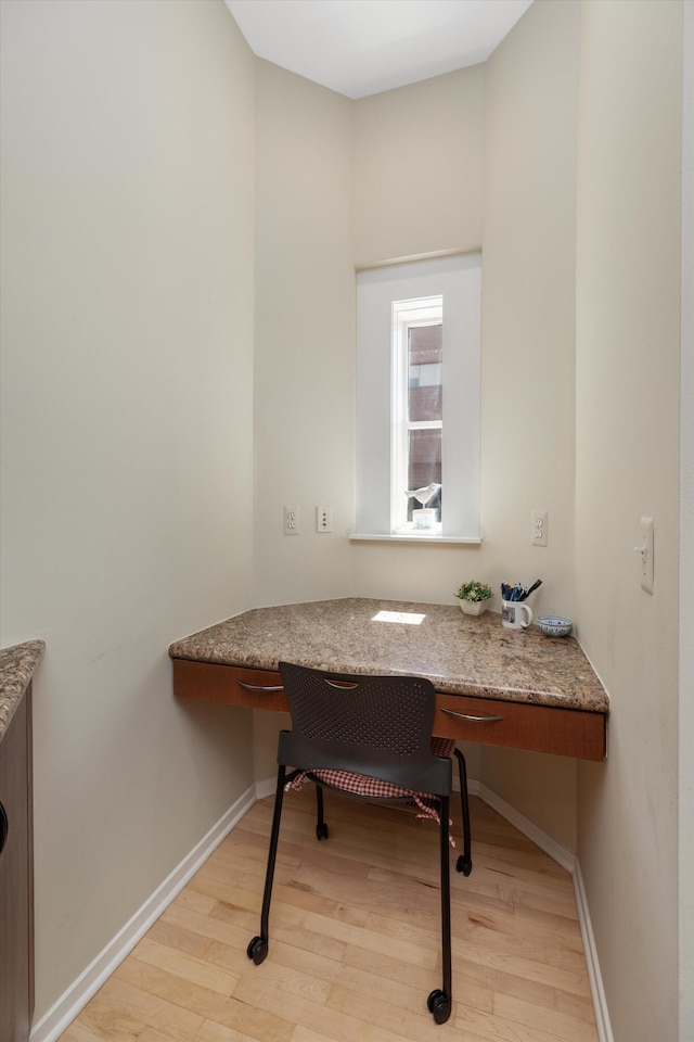 office area featuring built in study area, light wood-style flooring, and baseboards