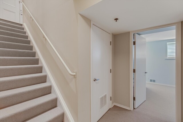 stairway featuring visible vents, carpet flooring, and baseboards