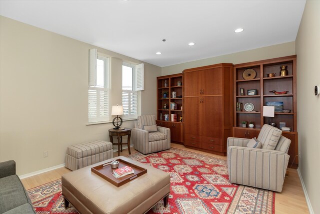 living area featuring recessed lighting, baseboards, and light wood-style flooring