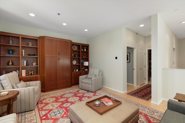 living room with recessed lighting, baseboards, and light wood-style floors