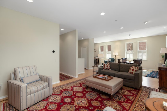living area with recessed lighting, baseboards, and light wood finished floors