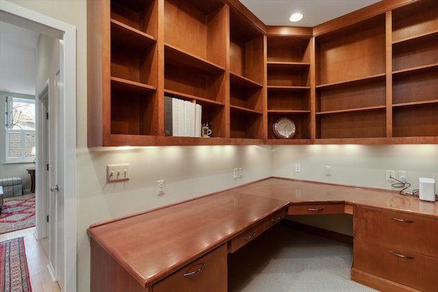 unfurnished office with light carpet and built in desk