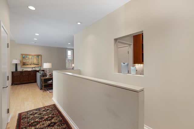 hall featuring recessed lighting, an upstairs landing, and light wood-style flooring