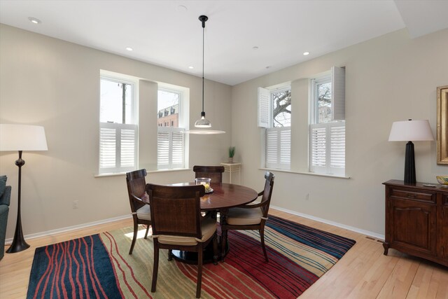dining room with plenty of natural light, light wood finished floors, and baseboards