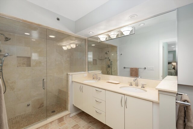 ensuite bathroom featuring ensuite bathroom, a sink, double vanity, and a shower stall