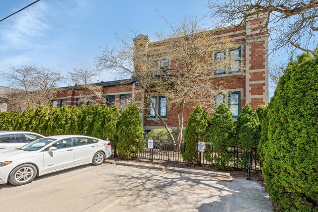 view of property with uncovered parking and fence
