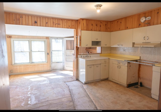 kitchen with light countertops, decorative backsplash, and under cabinet range hood