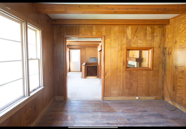 corridor featuring wood walls, beam ceiling, and hardwood / wood-style flooring