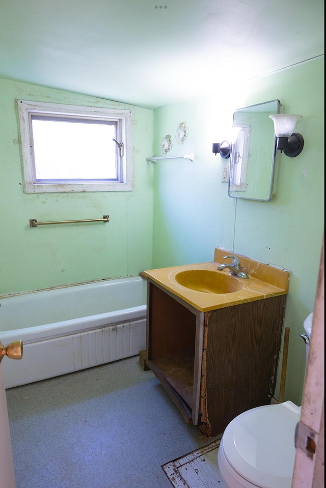 bathroom with vanity, a bathing tub, and toilet