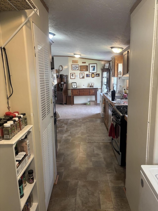 kitchen featuring gas range oven, a textured ceiling, and light countertops