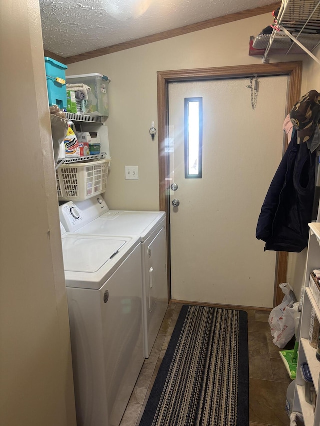 clothes washing area with laundry area, a textured ceiling, and washer and clothes dryer