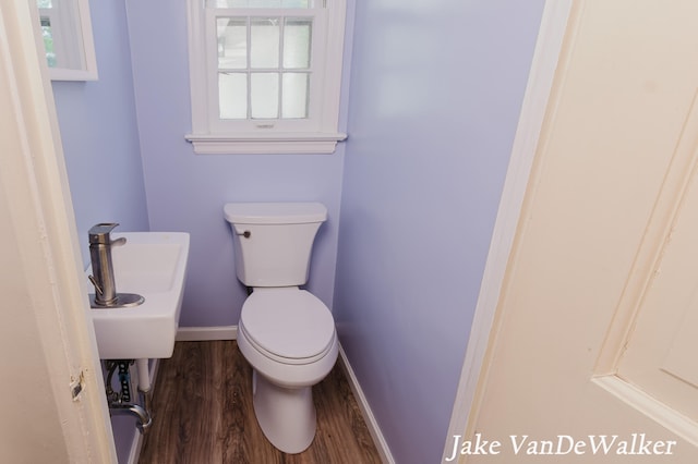 bathroom with baseboards, toilet, and wood finished floors