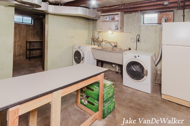 laundry area with laundry area, separate washer and dryer, and a wealth of natural light