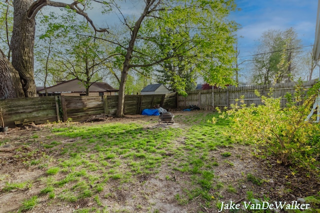 view of yard featuring a fire pit and a fenced backyard