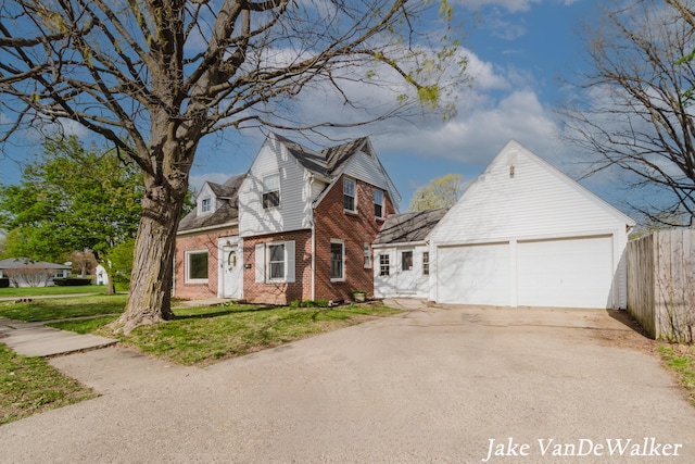 view of front facade featuring fence, a front lawn, brick siding, a garage, and concrete driveway
