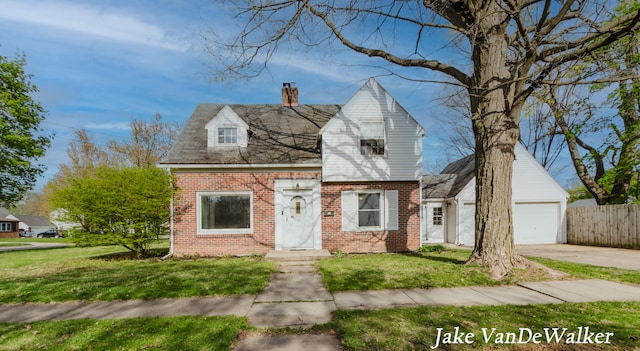 cape cod house featuring a garage, a front lawn, a chimney, brick siding, and concrete driveway