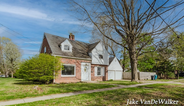 cape cod house with fence, a chimney, a front yard, and brick siding