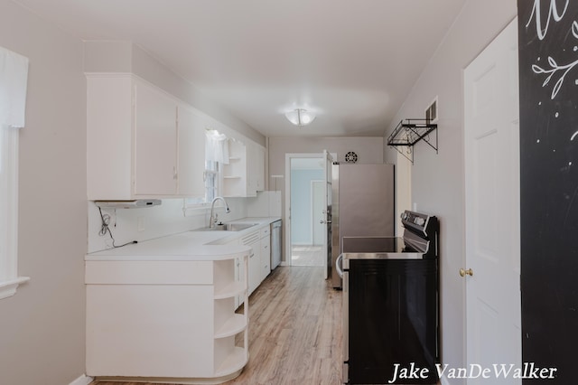 kitchen with white cabinets, open shelves, a sink, light wood finished floors, and black range with electric stovetop