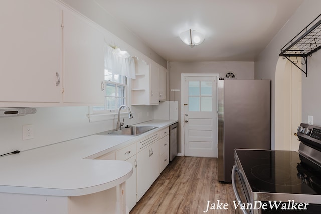 kitchen with open shelves, appliances with stainless steel finishes, a sink, light countertops, and white cabinetry