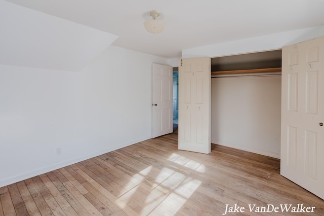 unfurnished bedroom featuring a closet, baseboards, and light wood-style floors
