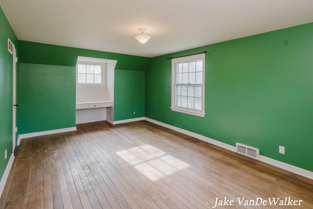 interior space featuring visible vents, baseboards, and hardwood / wood-style floors