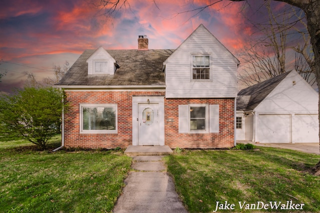 view of front facade with a yard, brick siding, a chimney, and a garage
