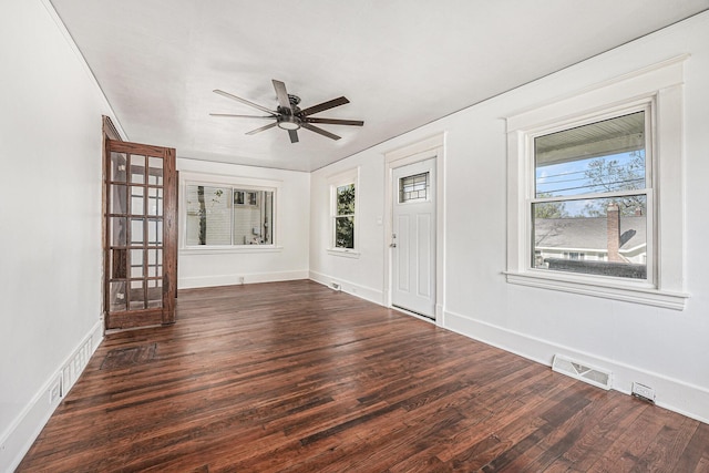 foyer featuring dark wood-style flooring, a ceiling fan, visible vents, and a healthy amount of sunlight