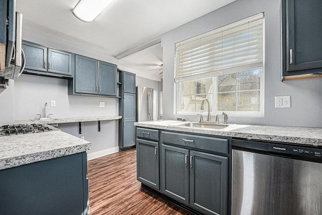 kitchen featuring a sink, light countertops, stainless steel appliances, and dark wood finished floors