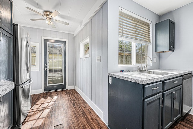 kitchen featuring baseboards, light countertops, a sink, dark wood finished floors, and appliances with stainless steel finishes
