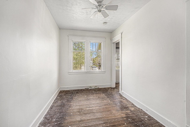 spare room with baseboards, a textured ceiling, and dark wood-style flooring