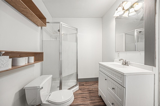 full bath with toilet, a shower stall, wood finished floors, and vanity