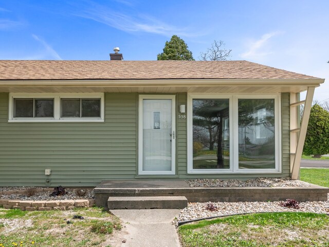 property entrance with roof with shingles