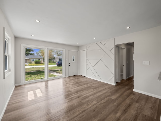 unfurnished living room with baseboards, recessed lighting, and wood finished floors