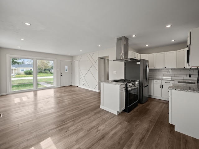 kitchen with stainless steel appliances, light stone countertops, a sink, and island range hood