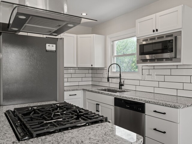 kitchen with a sink, appliances with stainless steel finishes, and white cabinets