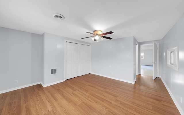 unfurnished bedroom featuring light wood finished floors, baseboards, and a closet
