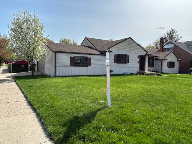 19852 Martin Rd, Saint Clair Shores, MI 48081 - view of front of home with a front lawn, driveway, and a garage