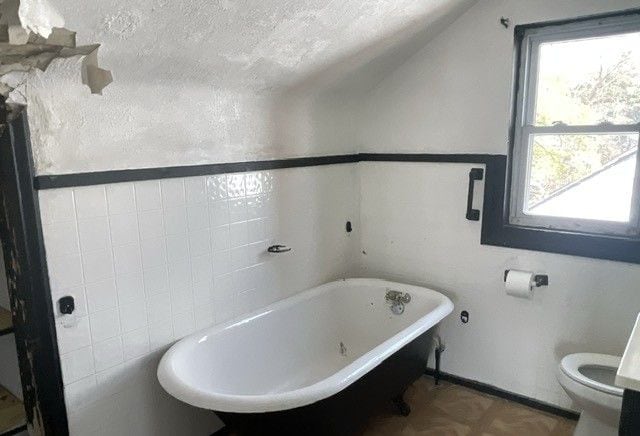 16837 Winthrop St, Detroit, MI 48235 - bathroom with a textured ceiling, lofted ceiling, a freestanding bath, and toilet