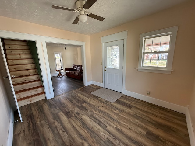 entrance foyer featuring a ceiling fan, baseboards, wood finished floors, and a textured ceiling
