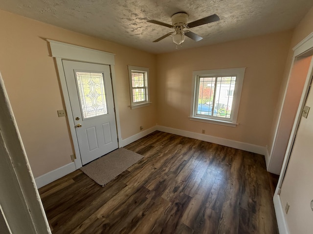 entrance foyer with baseboards, a ceiling fan, dark wood finished floors, and a textured ceiling